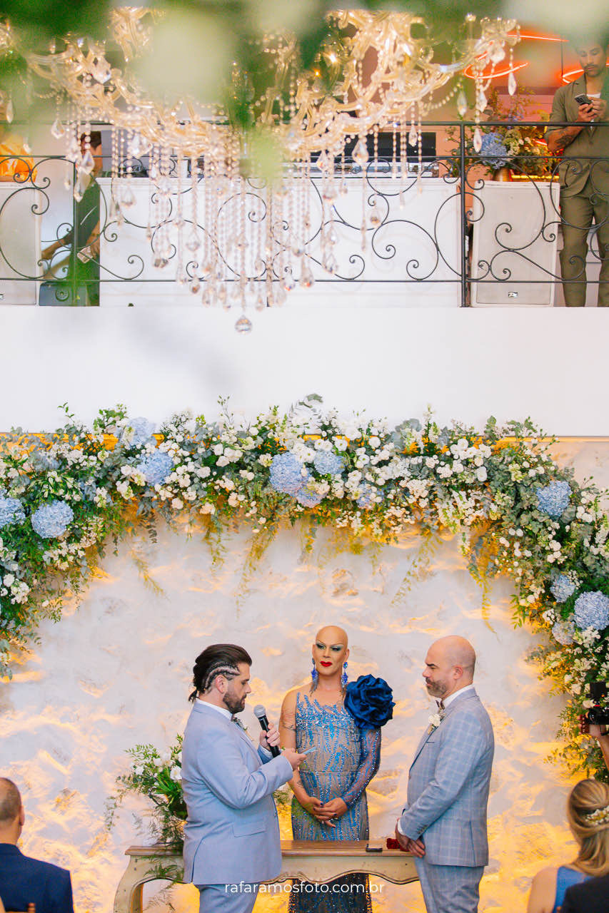 Fotografia de casamento gay, noivos sorrindo felizes durante cerimônia ao ar livre no Chalé Quintal