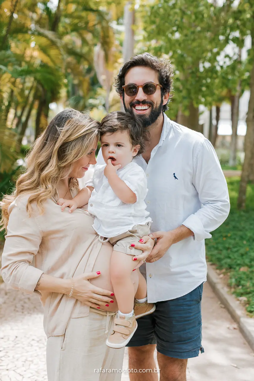 Família sorrindo em ensaio gestante em Pinheiros SP, fotografada por Rafa Ramos — momento de carinho entre pais e filho ao ar livre.