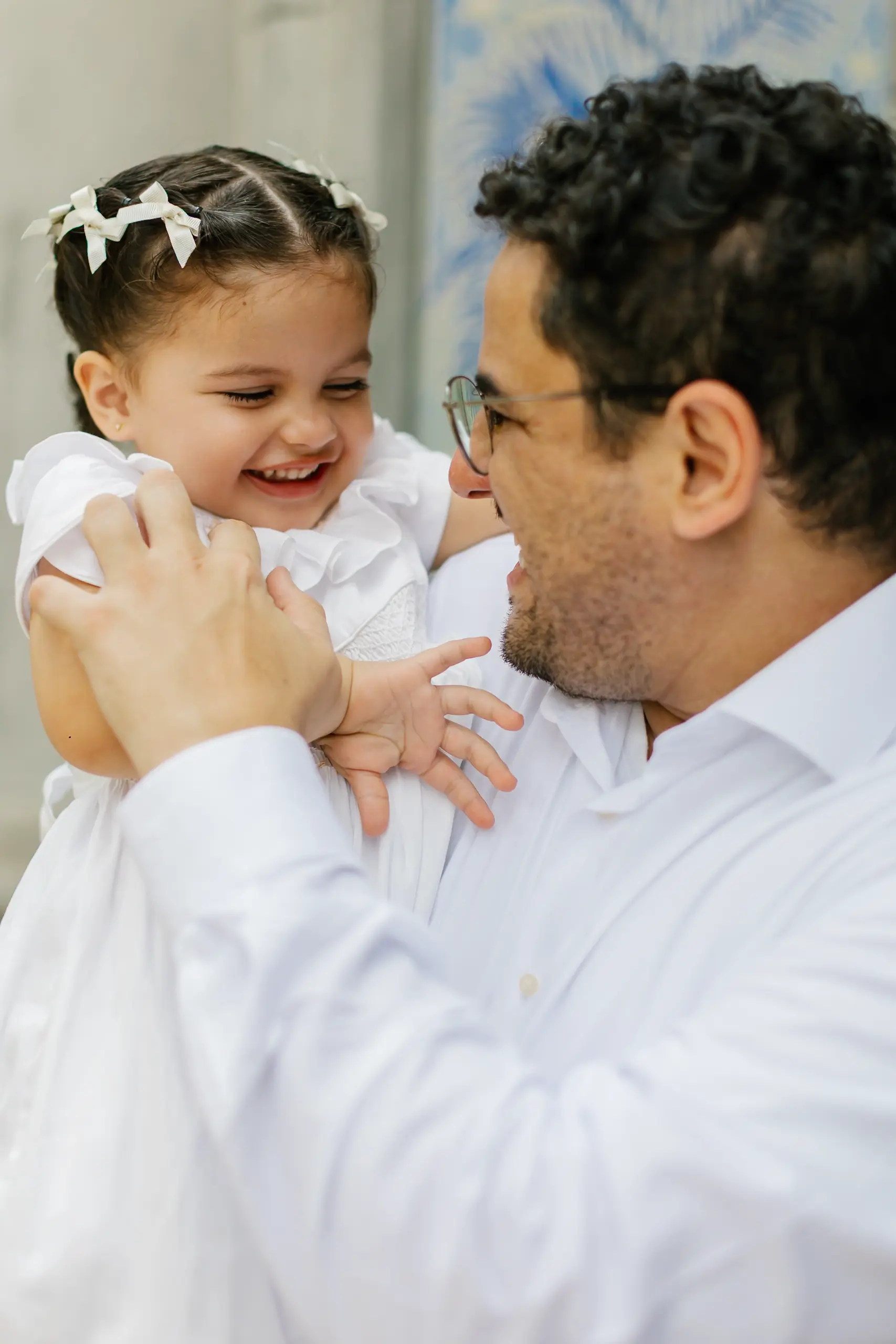 Criança sendo acolhida no colo durante batizado na Igreja Nossa Senhora do Brasil