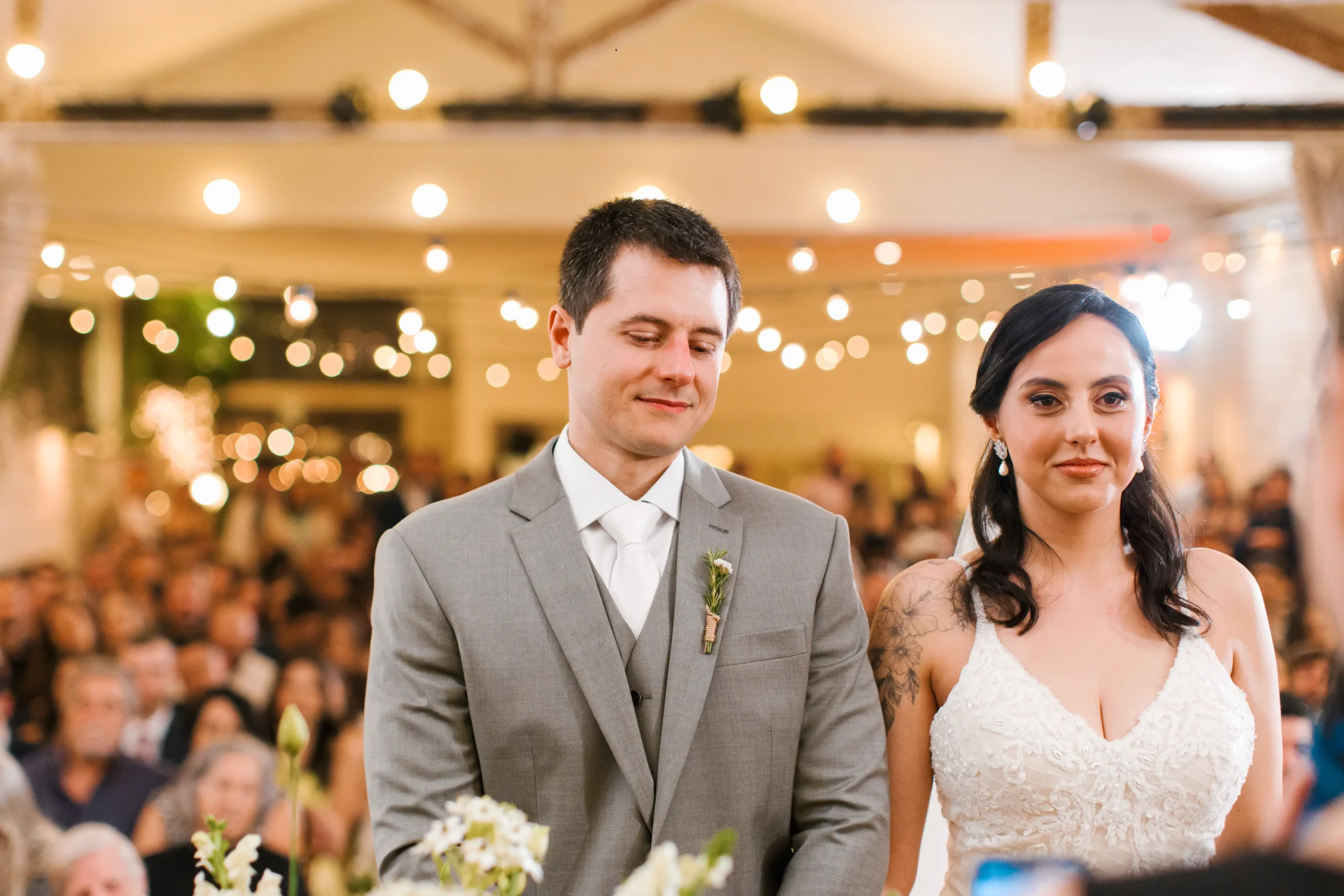 celebrante conduzindo cerimônia de casamento no Celeiro Quintal enquanto os noivos se seguram pelas mãos