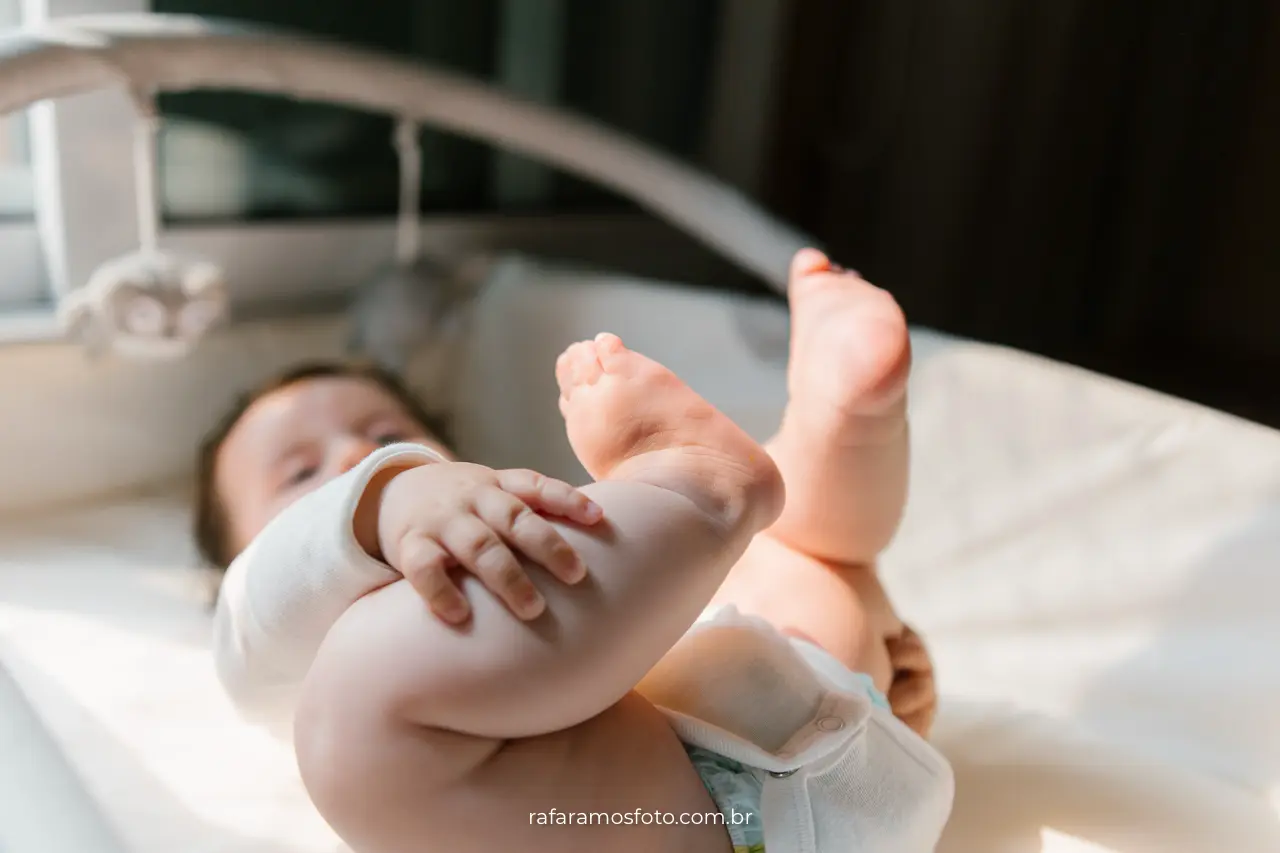 Fotógrafo de bebê em SP — bebê deitado com expressão tranquila em ambiente doméstico