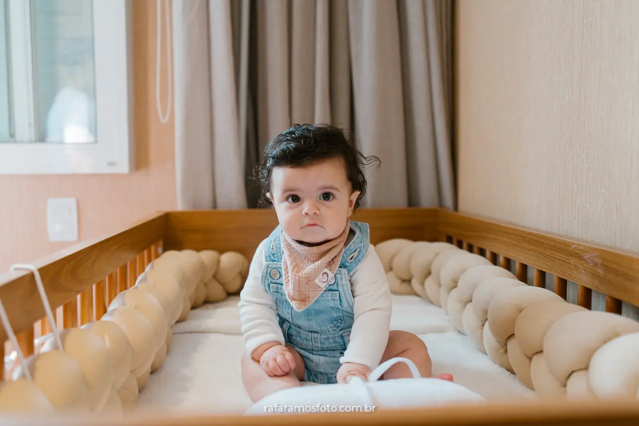 Fotografia de bebê em casa — bebê brincando com expressão de curiosidade